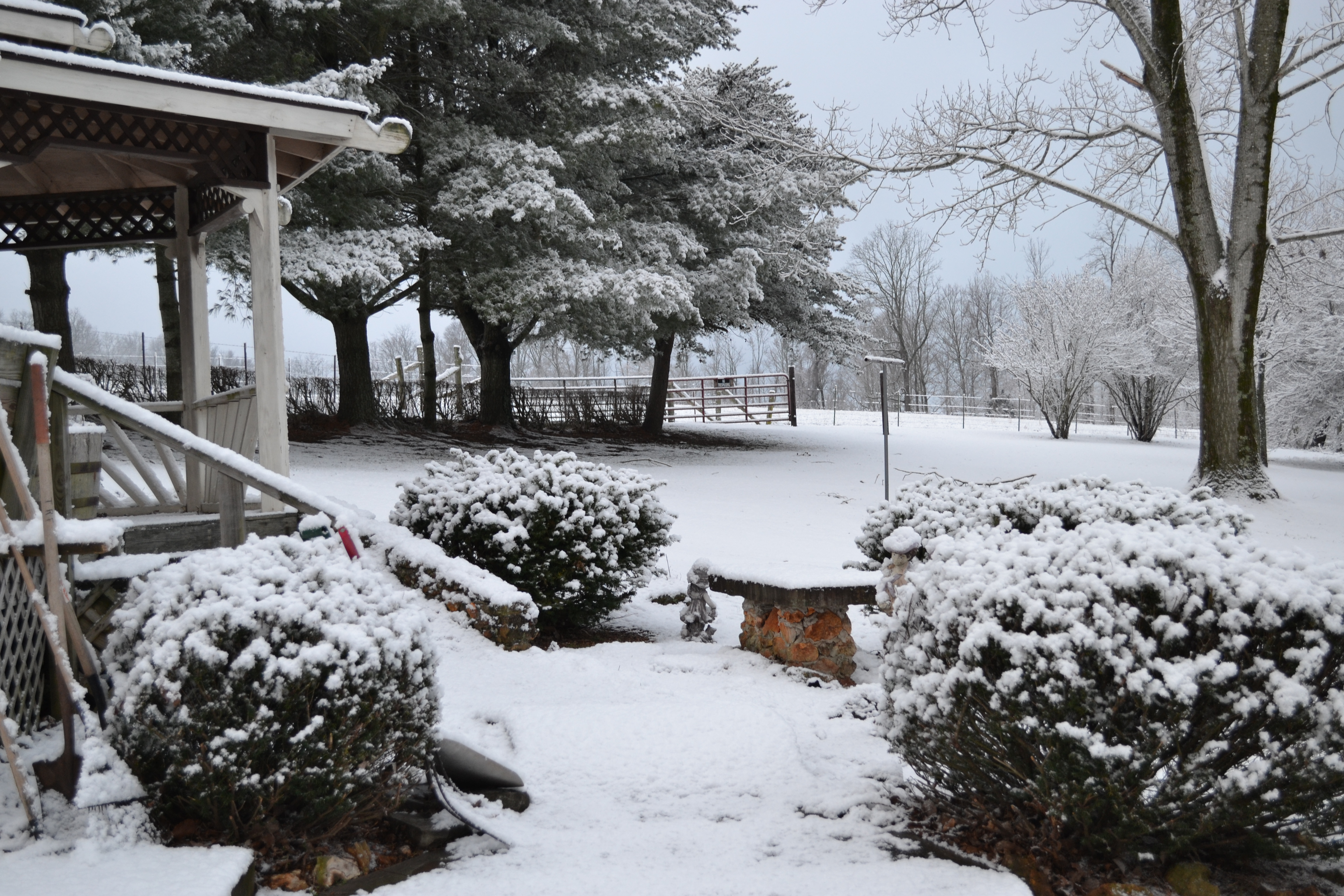 Stone exterior home with covered porch in winter snow