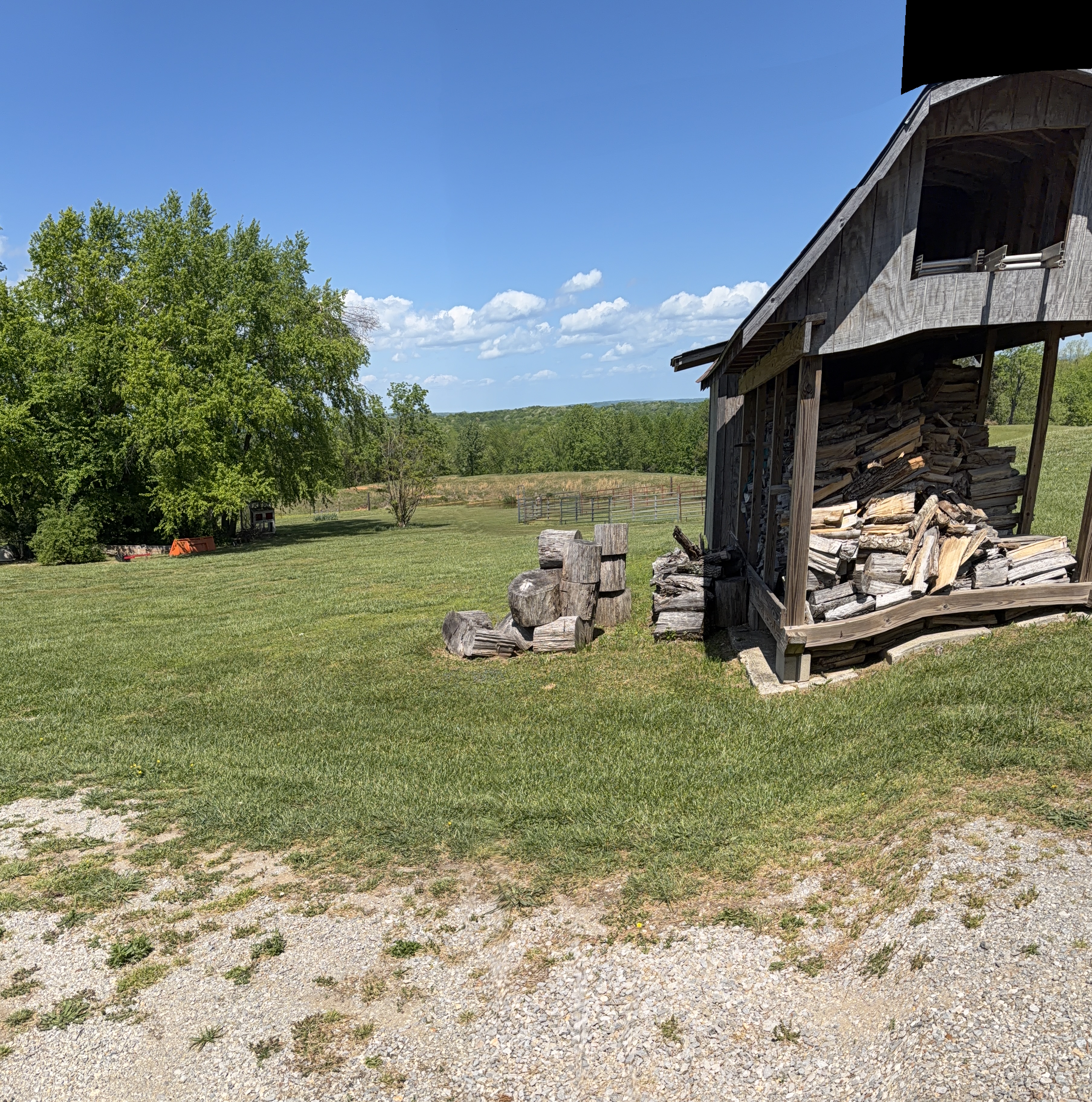 Stone exterior of the residence with barn behind