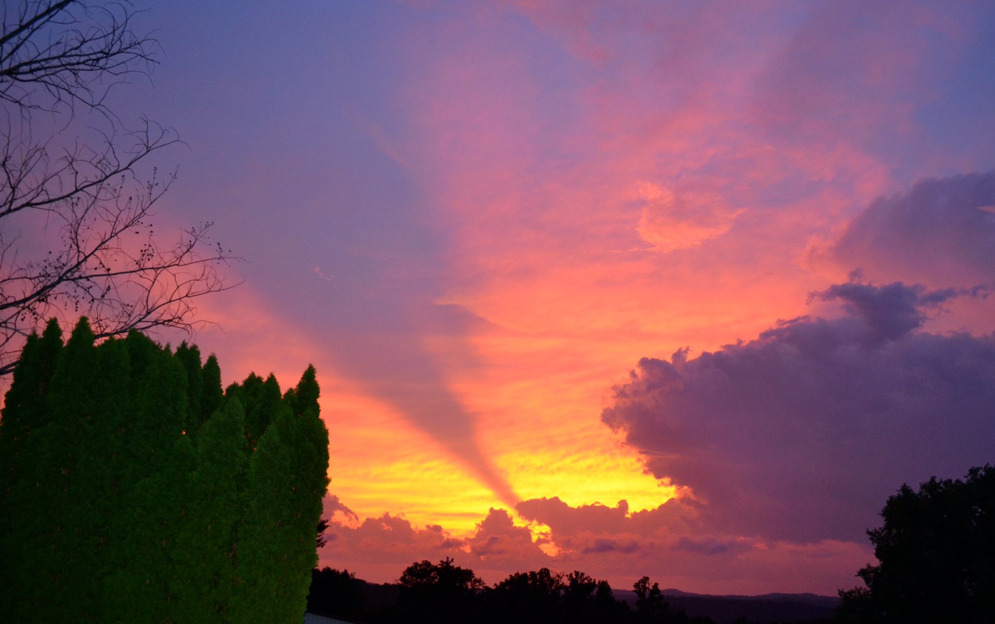 Dramatic pink, gold and purple sunset with rays over the valley